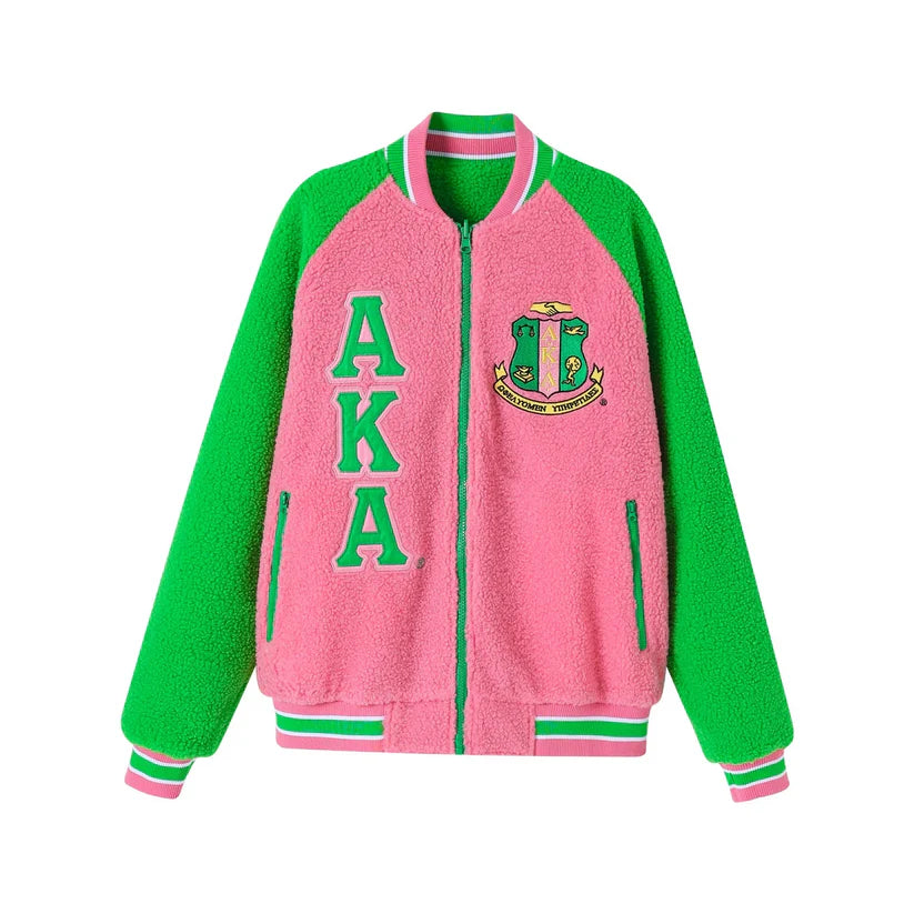 "Unisex Alpha Kappa Alpha (AKA) reversible bomber jacket featuring red and white sherpa material, embroidered appliqué logos, knit ribbing at the neck, cuffs, and waistband, offering cozy warmth and two stylish looks in one."