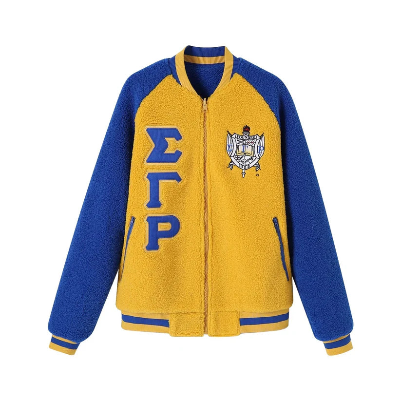 Image showing the Sigma Gamma Rho (SGRho) Reversible Sherpa Bomber Jacket with one side in blue/gold sherpa and the reverse side in a sleek coordinating material. Highlights the soft, cozy texture and the embroidered appliqué logo.