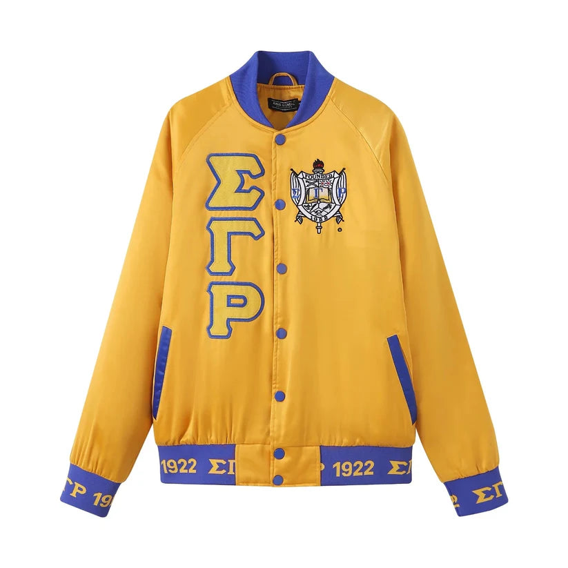 A close-up of the Sigma Gamma Rho (SGRho) Gold Satin Bomber Jacket, highlighting the smooth, glossy satin material and the contrasting royal blue custom ribbing and buttons. Shows the embroidered SGRho logo.