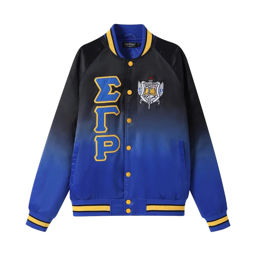 A close-up of the Sigma Gamma Rho (SGRho) Black Ombré Bomber Jacket, highlighting the smooth satin material and the sleek fade from black to royal blue. Shows the embroidered appliqué logo and royal blue knit ribbing.