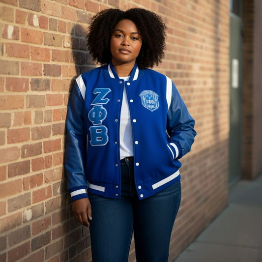 Full-length image of a model wearing the Royal Blue and White Zeta Wool and Leather Letterman Jacket. The jacket features a classic varsity design with a warm cashmere wool body and premium leather shoulders in a comfortable, unisex fit.