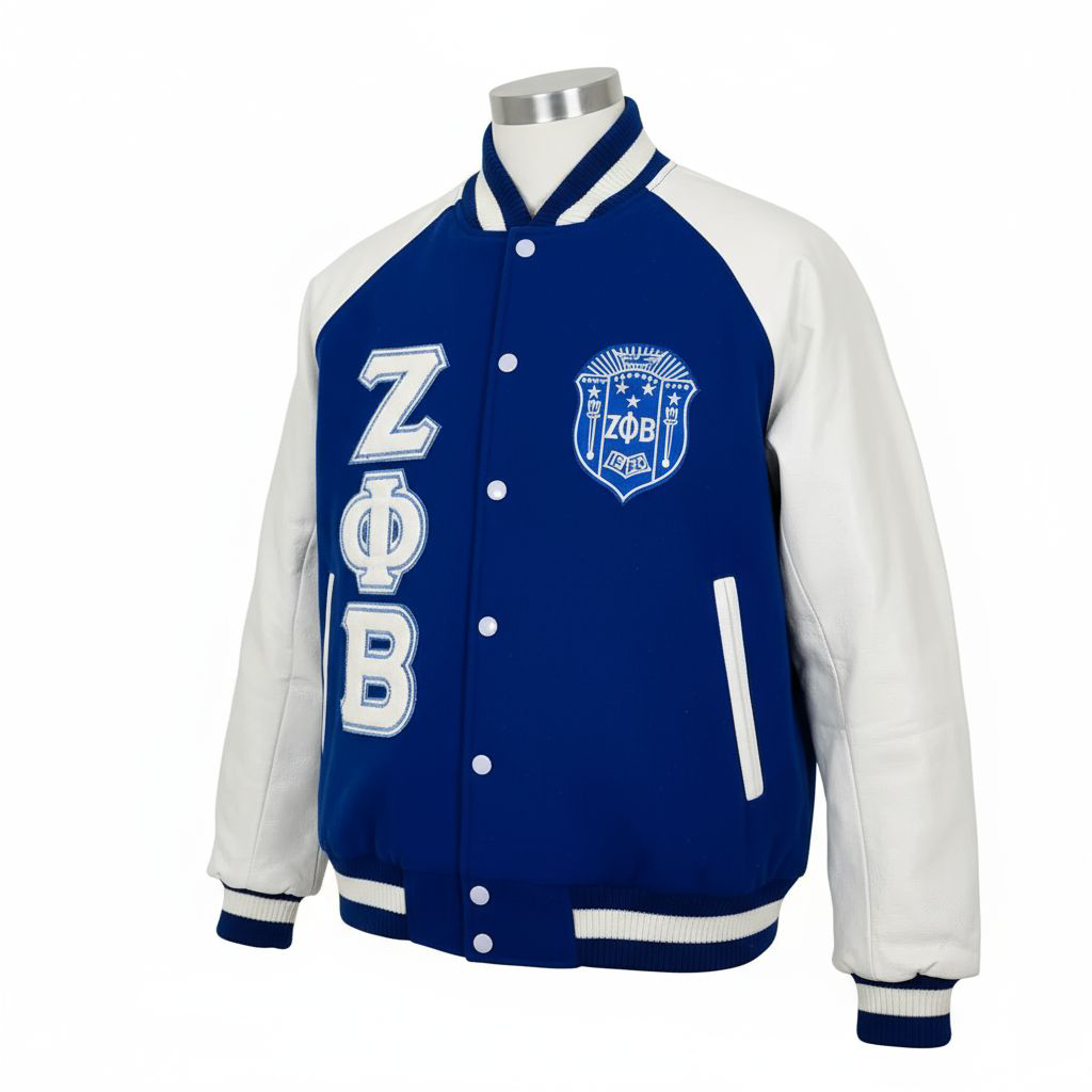 A close-up of the Zeta Letterman Jacket showing the luxurious Royal Blue 100% cashmere wool body contrasting with the smooth white 100% leather sleeves. Highlights the leather appliqué embroidered Zeta logo and custom ribbing.