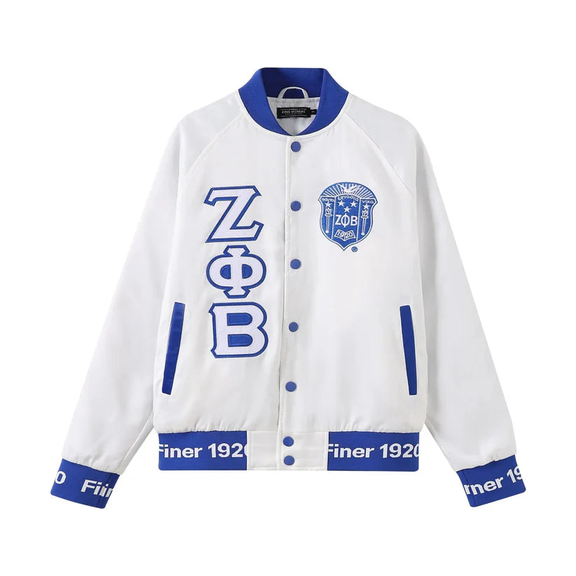 A close-up of the Zeta White Satin Bomber Jacket, highlighting the smooth, glossy satin material and the contrasting Royal Blue custom ribbing and buttons. Shows the embroidered Zeta logo and the quality details.