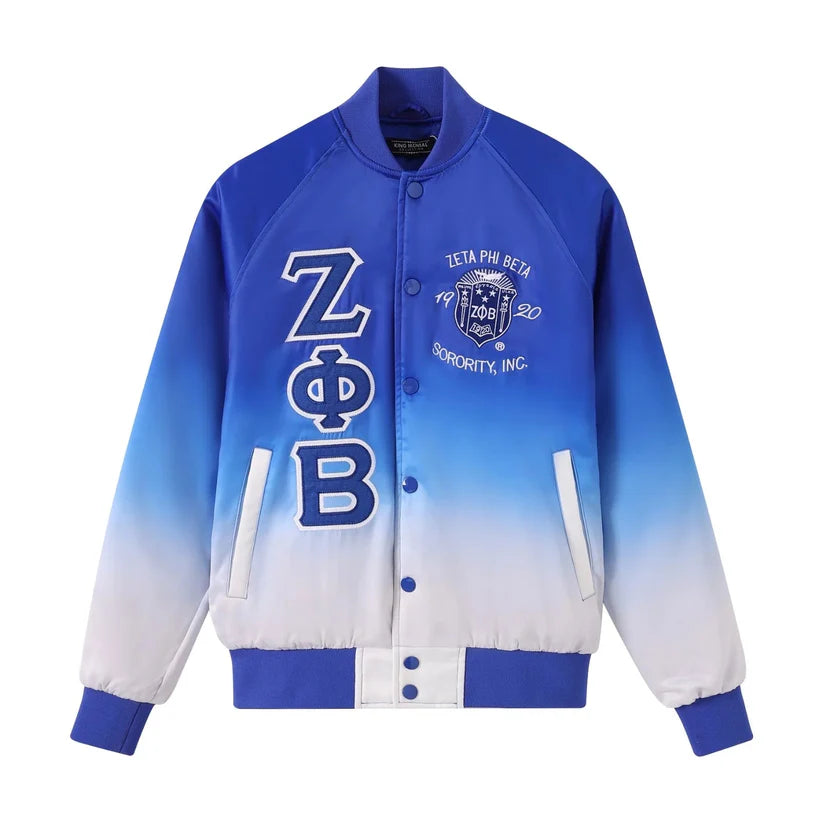 The Zeta Faded Bomber Jacket showcasing the smooth satin material and the unique Royal Blue fade to White color design. Highlights the embroidered Zeta logo, Royal Blue buttons, and ribbing.