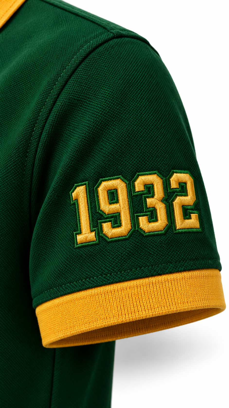 Close-up of gold 1932 sleeve embroidery and gold cuff on a dark green Chi Eta Phi polo shirt