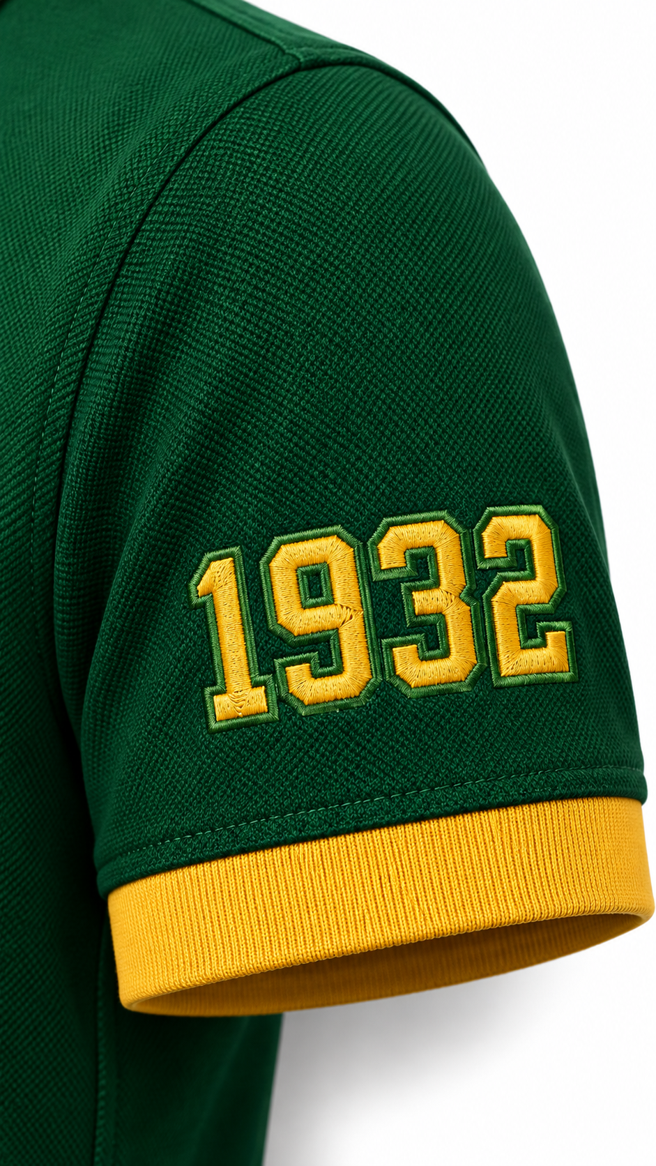 Close-up of gold 1932 sleeve embroidery and gold cuff on a dark green Chi Eta Phi polo