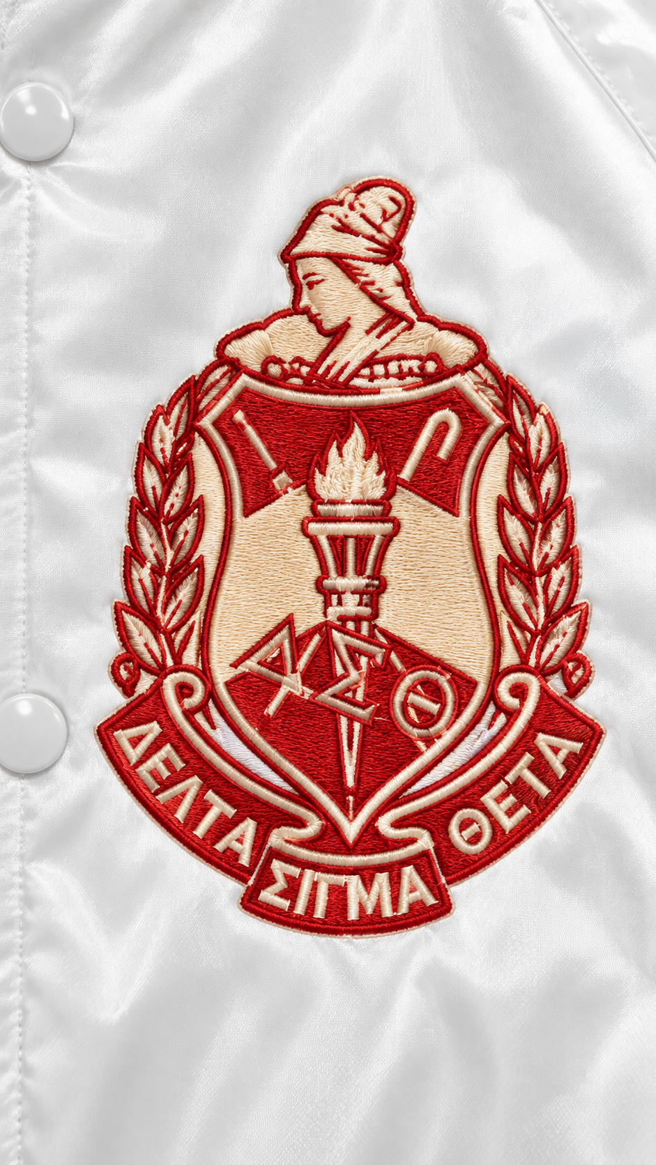 A close-up of a white satin or nylon jacket with a large embroidered Delta Sigma Theta crest patch on the front.