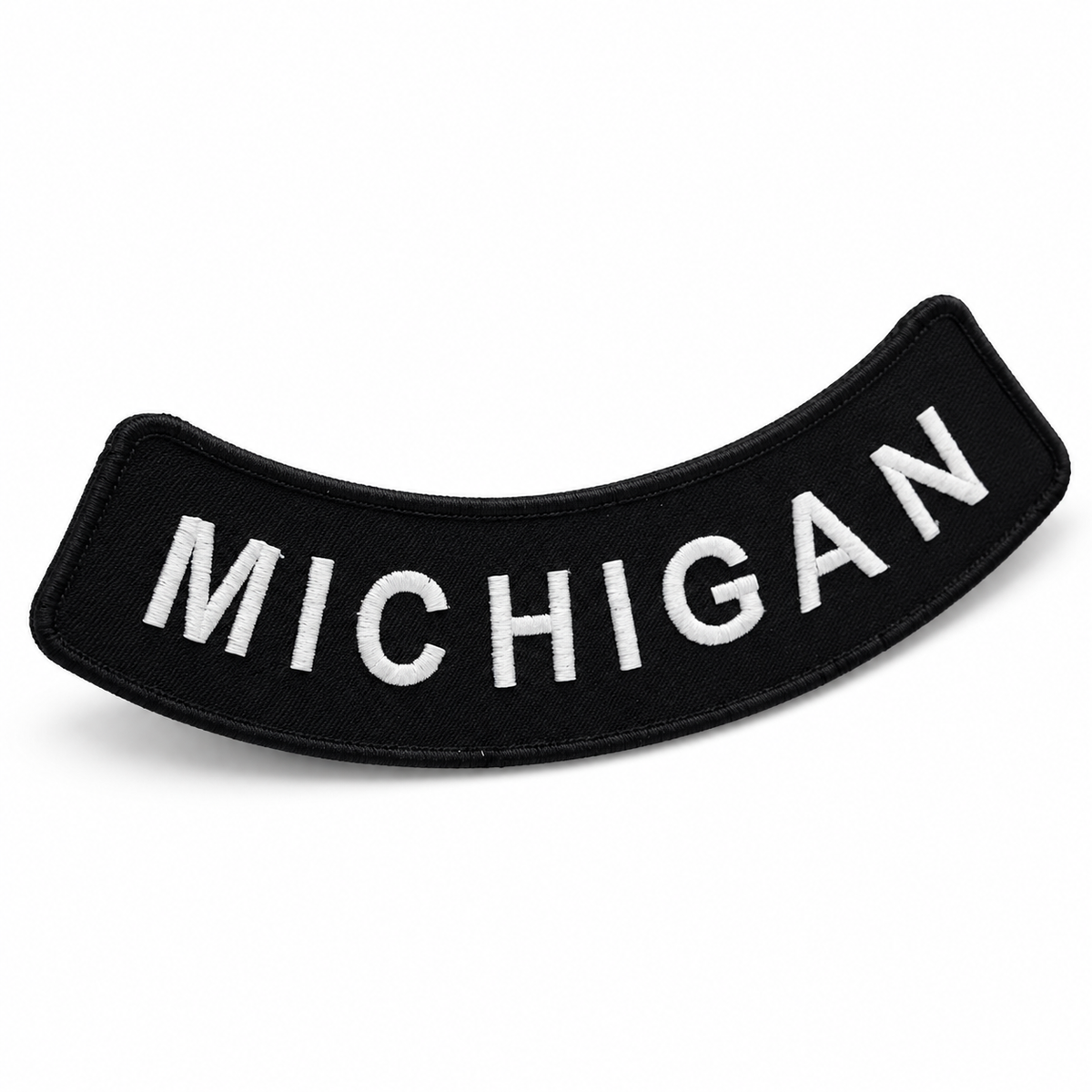 Michigan white on black embroidered bottom rocker patch — angled view showing curved shape