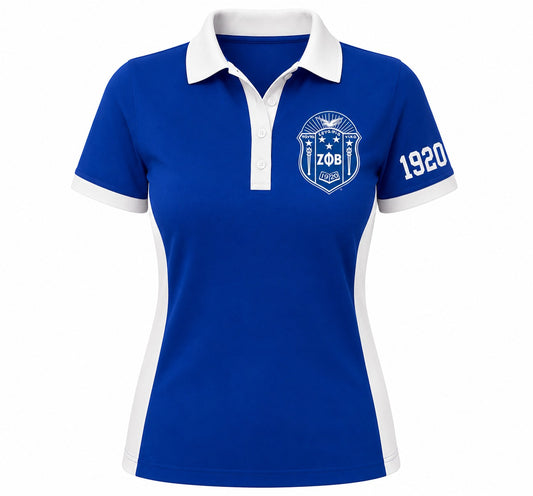 A women's short-sleeve polo shirt in royal blue with white accents, featuring a white collar, white sleeve trim, a white crest on the left chest with 'ZOB' and '1920' on the right sleeve, shown on a plain white background.